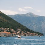 Experience the scenic beauty of Perast in the Bay of Kotor with mountainous backdrop.