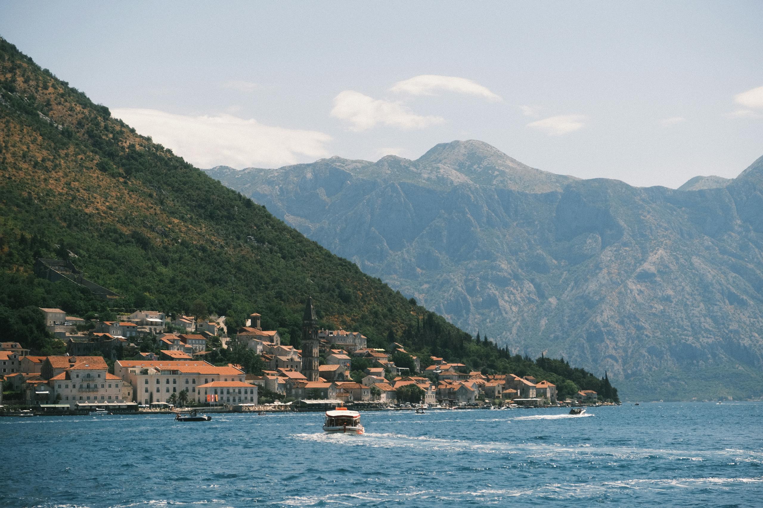 Experience the scenic beauty of Perast in the Bay of Kotor with mountainous backdrop.